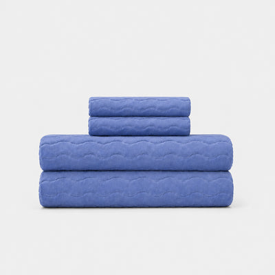 Cotton bath towel set with sculpted wave texture, neatly folded.