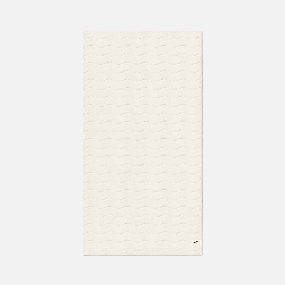 Cotton towel in cream color with plush, wavy texture, shown flat.
