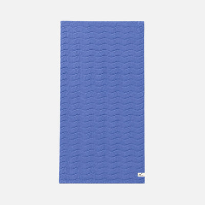 Blue cotton towel with wavy pattern, rectangular, displayed flat.