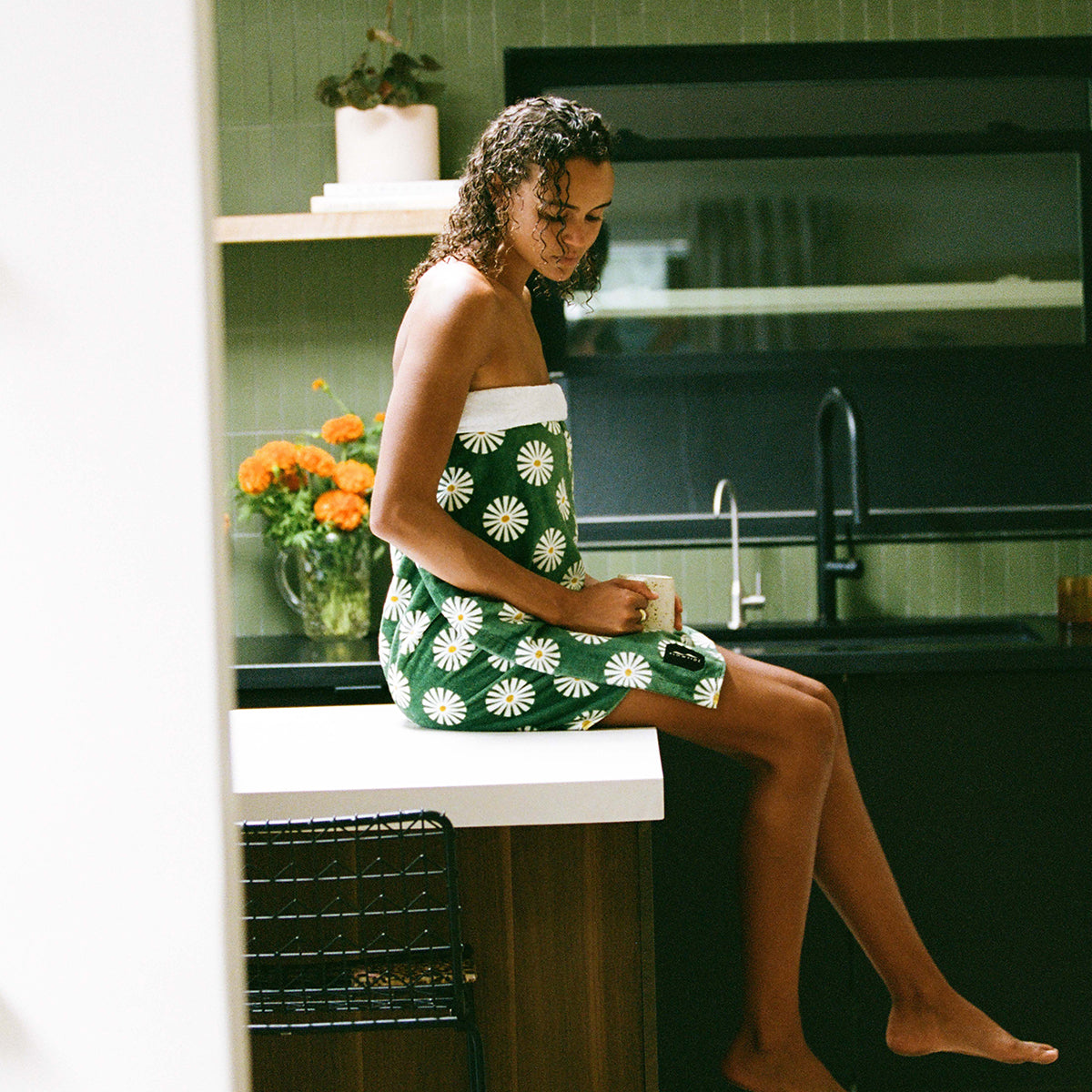 Cotton dish towel with daisy pattern on kitchen counter.