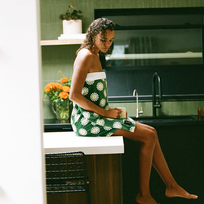 Cotton dish towel with daisy pattern on kitchen counter.