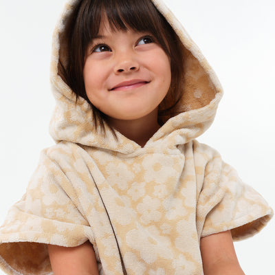 Kids poncho in beige with floral pattern, lightweight fabric.