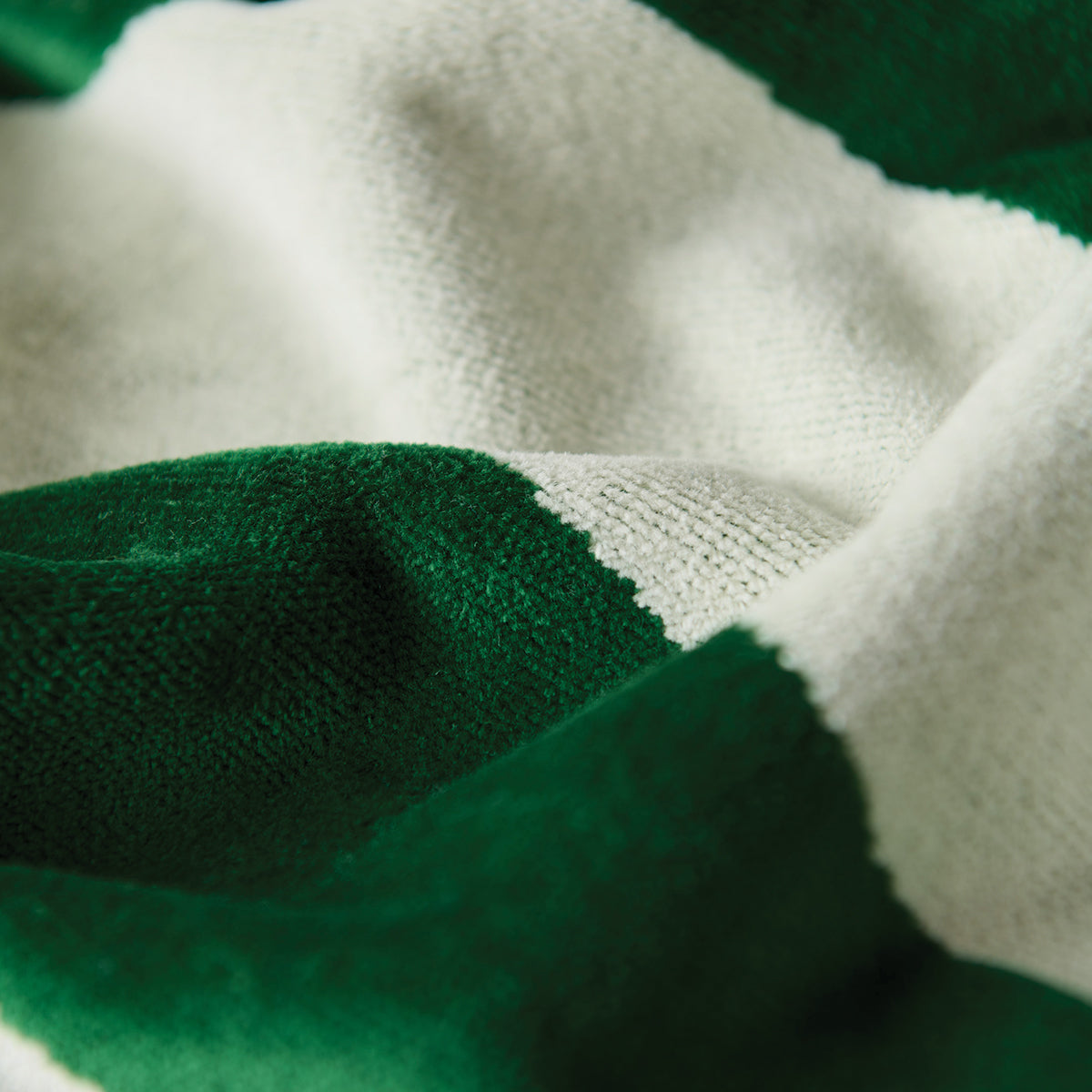 Towel, sustainable cotton, green and white stripes, close-up on texture and folds.