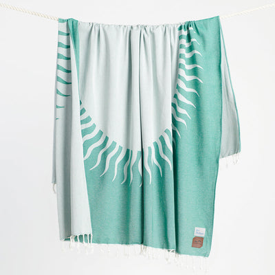 Turkish-style chambray blanket with teal and white sunburst design hanging on rope.