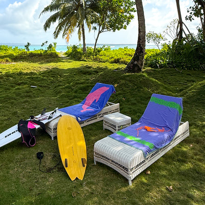 Lounge chairs with fast drying towels, shown on grass by the beach.