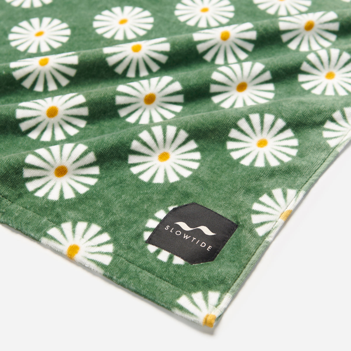 Cotton towel in green with white daisy pattern.