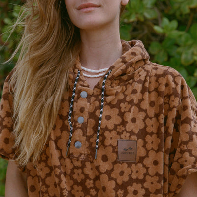 Brown absorbent poncho with floral pattern shown outside.