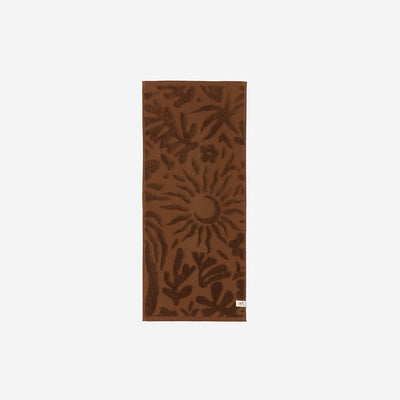 Brown cotton towel with sun-leaf botanical pattern, absorbent 550 GSM.