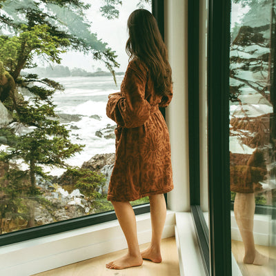 Brown embossed plush robe by an ocean-view window.