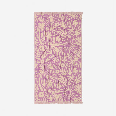 Towel with beige botanical print and fringe edges on white fabric.