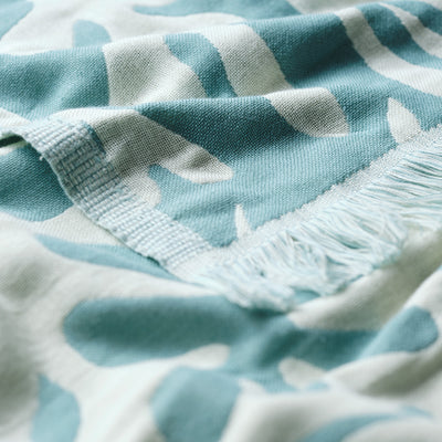 Blue and white woven fabric with fringe edges, close-up of pattern.