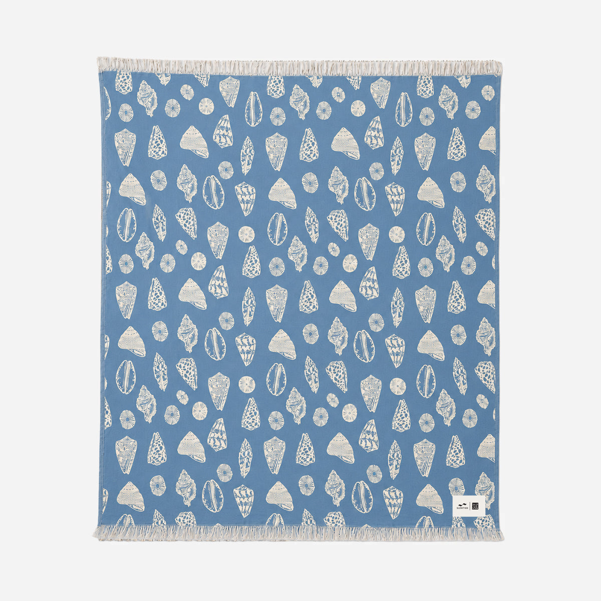 Cotton blanket with white geometric pattern and fringe, oversized and gauzy.