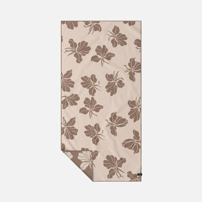 Microfiber travel towel with brown floral pattern for sand-free use.