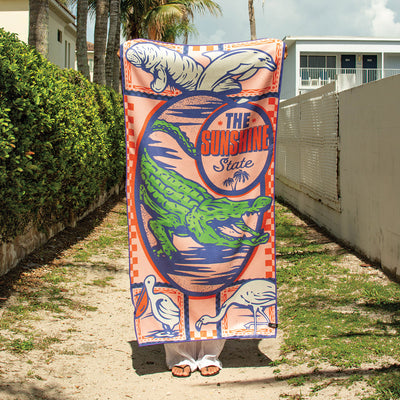 Travel towel with Florida-themed animal and palm tree print, lightweight for trips or beach use.