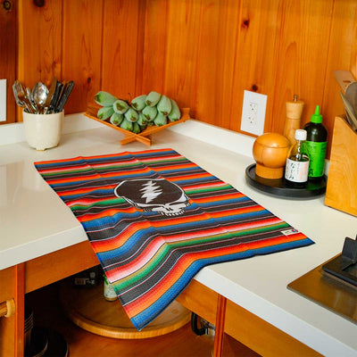 Quick-dry kitchen towel featuring a colorful striped pattern and skull icon.