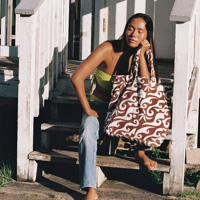 Large tote bag in toast color, carried outdoors in sunlight.