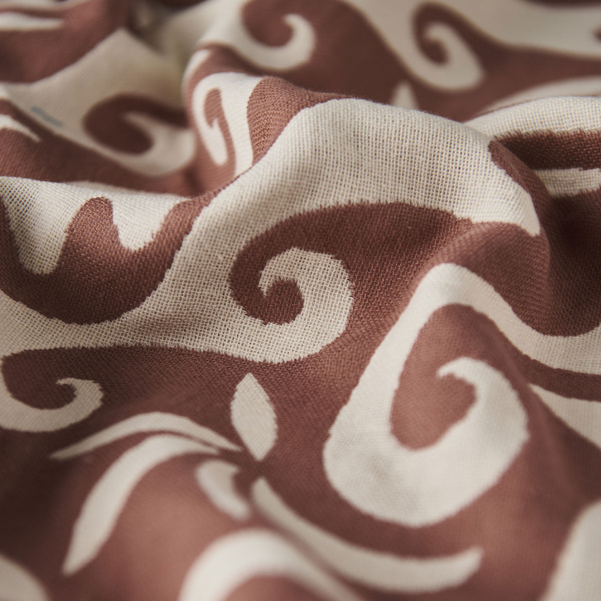 Towel with brown and white swirling wave pattern, slightly textured.