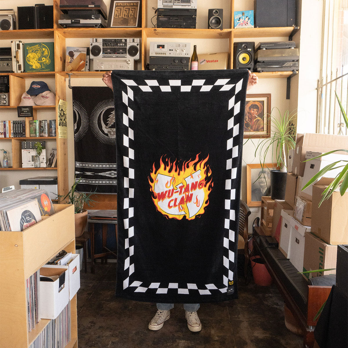 Towel with flaming logo graphic displayed indoors on shelving.