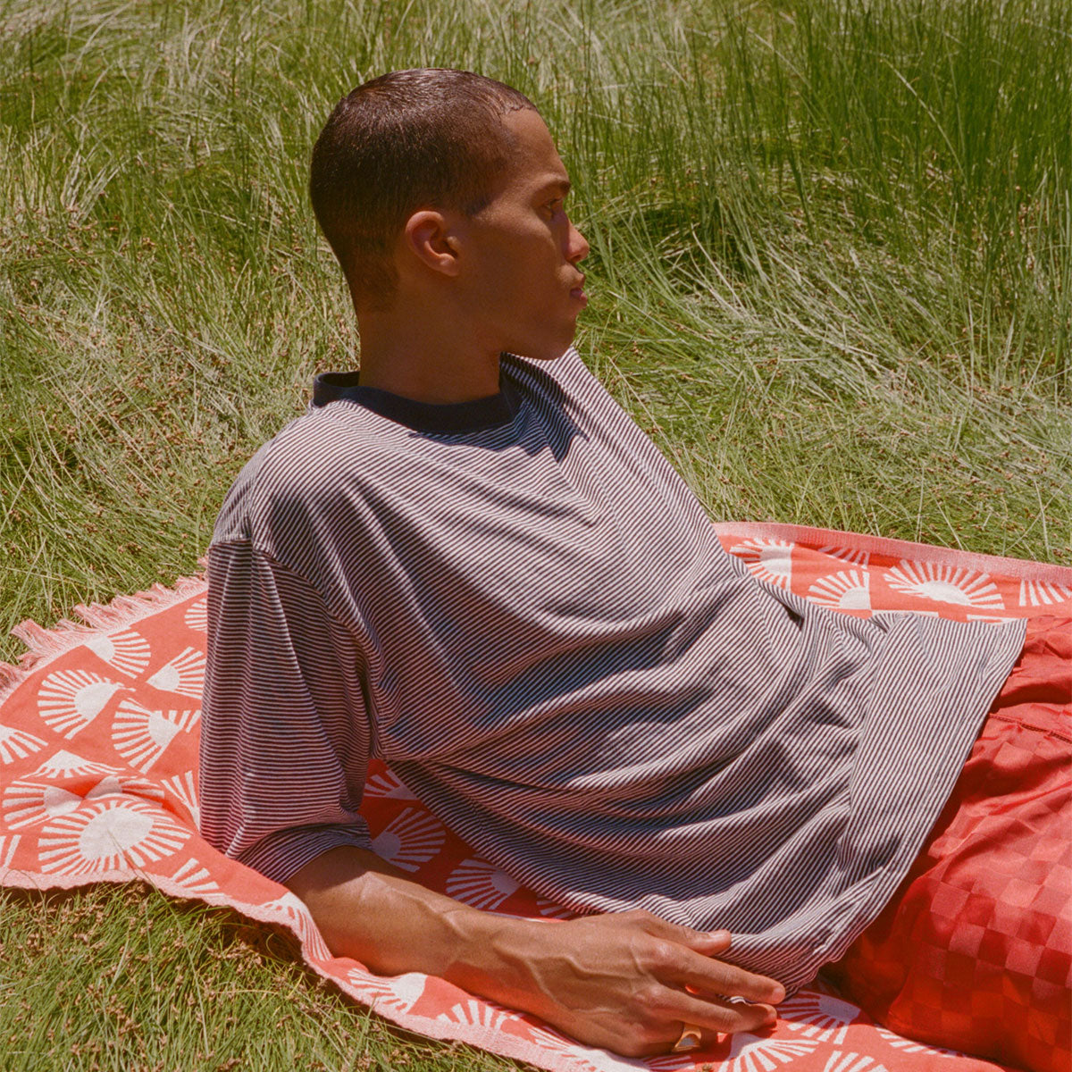 Turkish towel, sand-resistant fabric, striped pattern, displayed on grass.