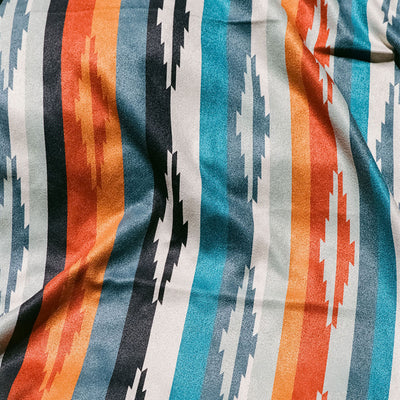 Oversized quick-dry towel with orange, blue, and black zigzag geometric pattern.