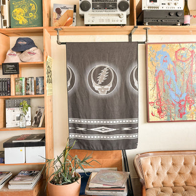 Blanket made from recycled materials with Grateful Dead design displayed in an indoor setting.
