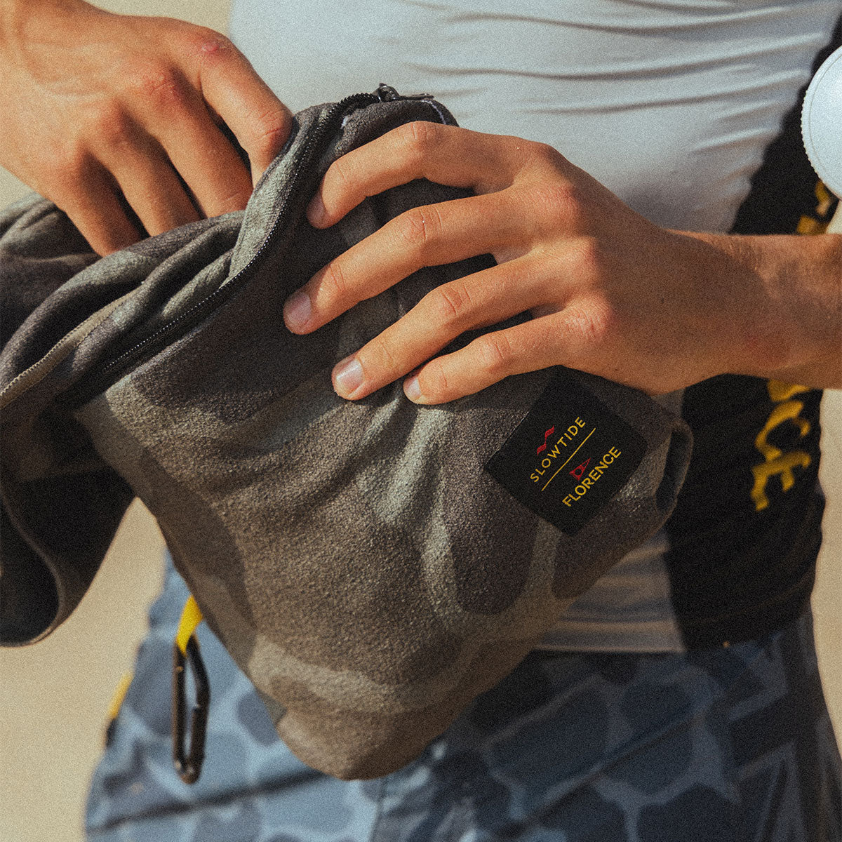Gray camo bag with quick dry camo print towel inside, unzipped to show contents.