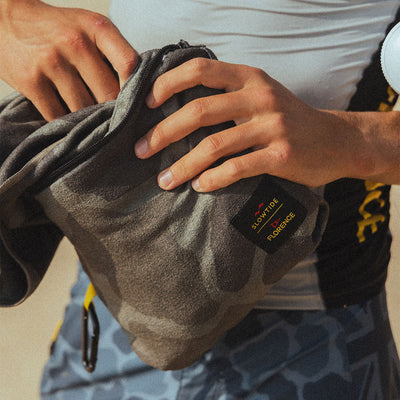 Gray camo bag with quick dry camo print towel inside, unzipped to show contents.