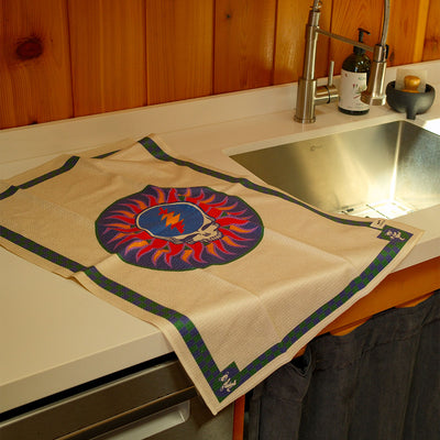 Cotton dish towel with skull and lightning bolt design on kitchen counter.