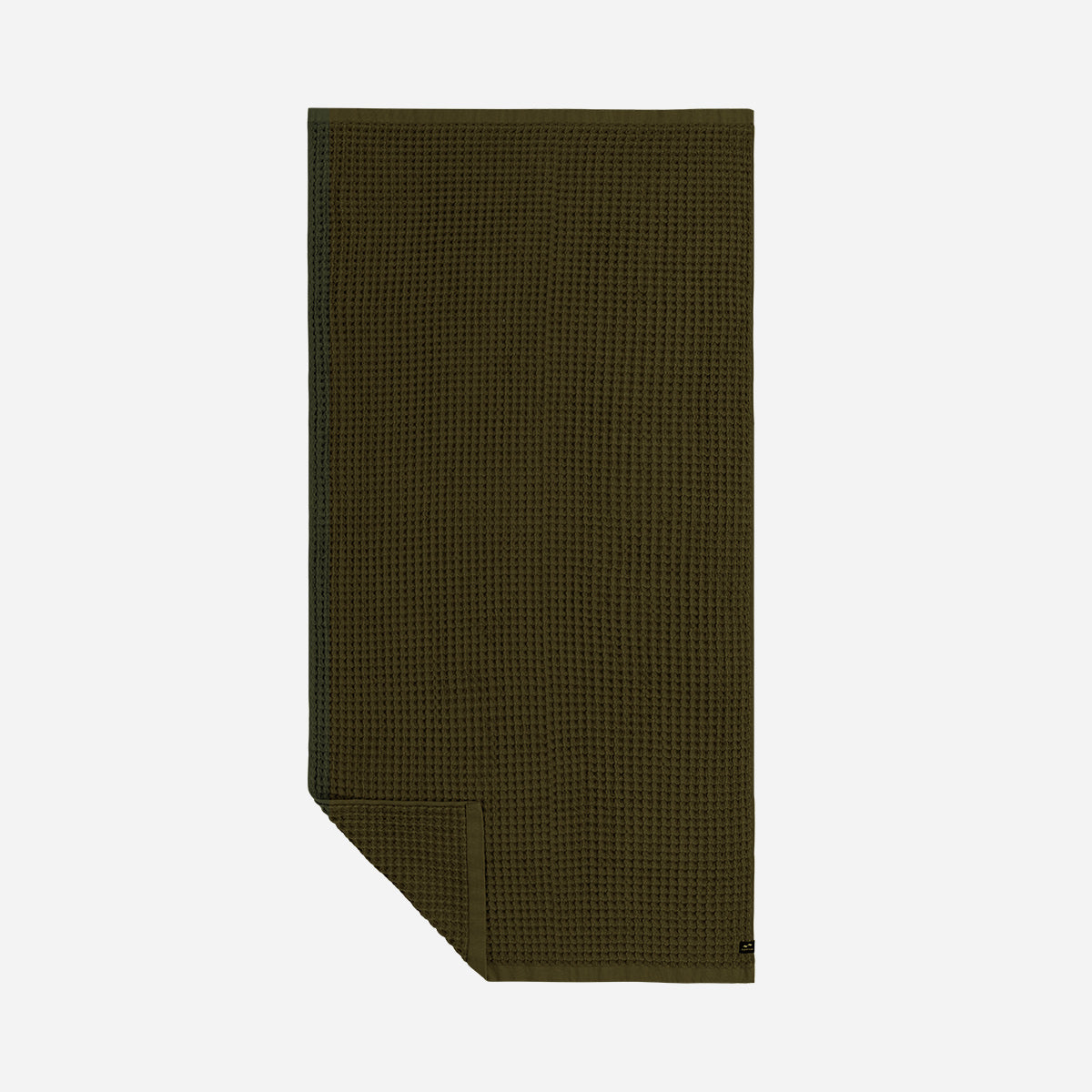 Oversized dark green waffle-textured towel, folded corner, white background.