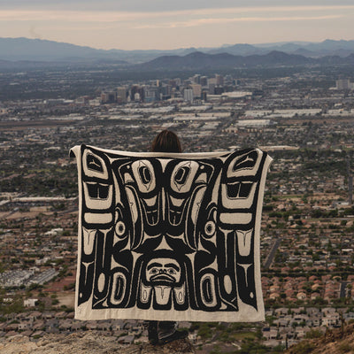 Tlingit blanket with Eagle pattern, woven textile displayed outdoors.
