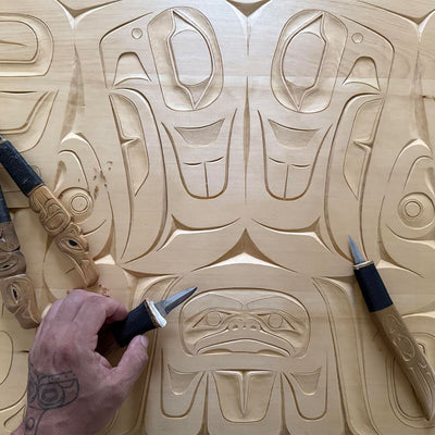 Wood decor piece with intricate Indigenous patterns, detailed like woven kitchen towels.