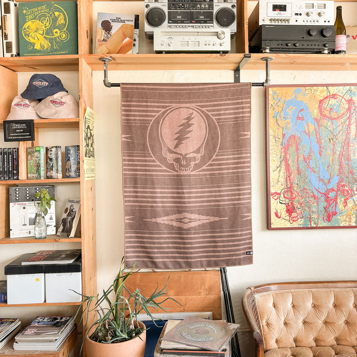 Brown recycled-material towel with graphic pattern displayed above a tan couch and shelves.