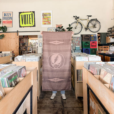 Brown recycled-material towel with graphic print on display in a vintage shop setting.