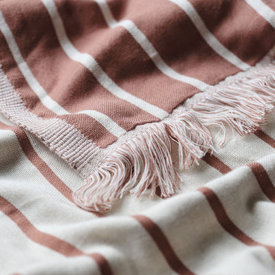 Reversible fabric with earthy tones and terracotta stripes, lightweight texture shown up close.