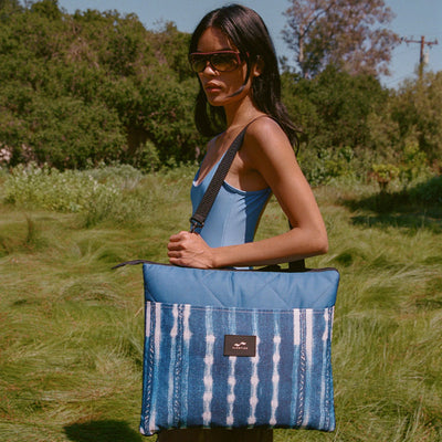 Water-resistant blue tote bag with a quilted top and vertical stripes.