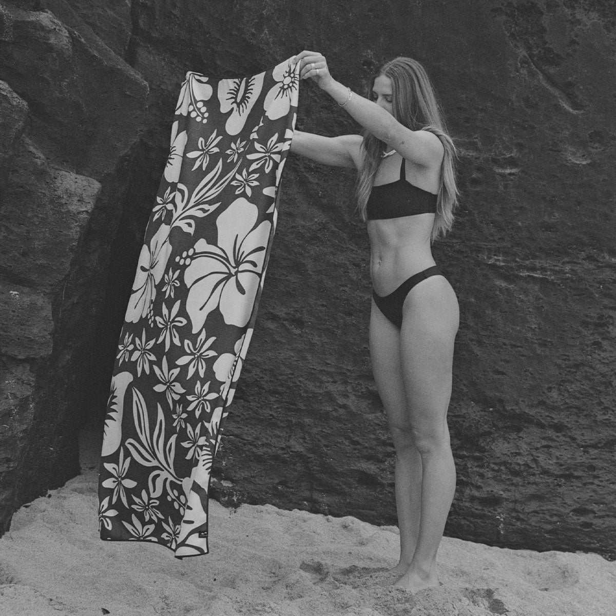 Quick-drying beach towel with a white floral pattern.