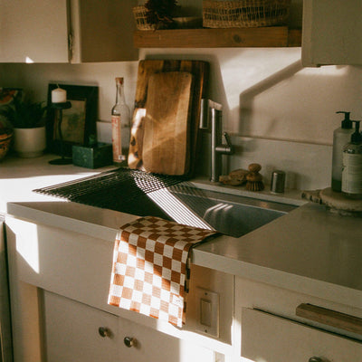 Quick dry towel on kitchen counter edge in natural sunlight.