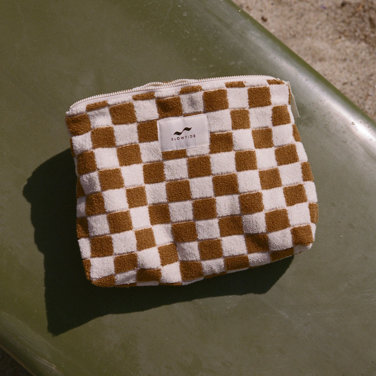 Terry zippered pouch in a brown and white checkered pattern for travel.