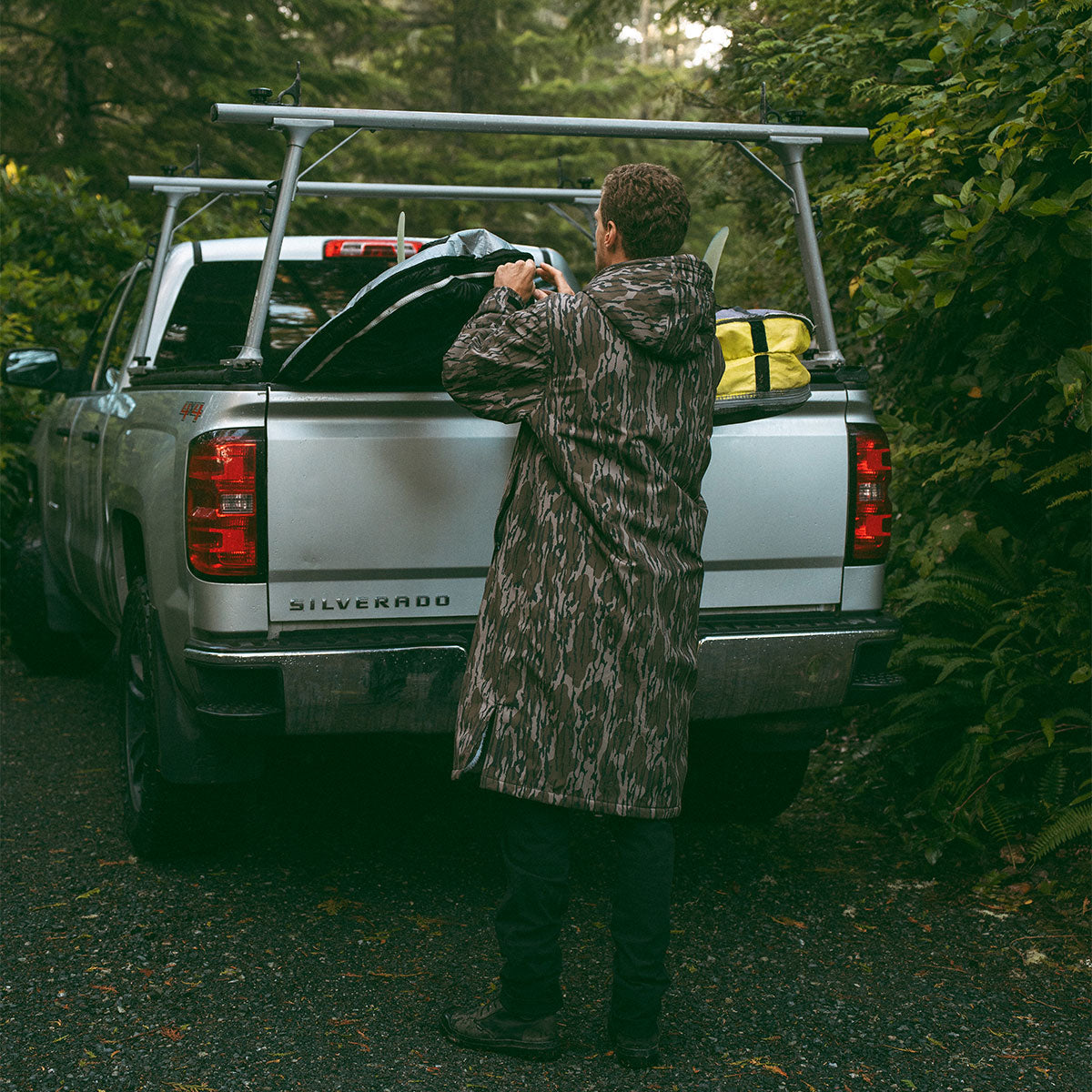 Camo all-weather jacket with rugged pattern outdoors near a silver pickup truck.