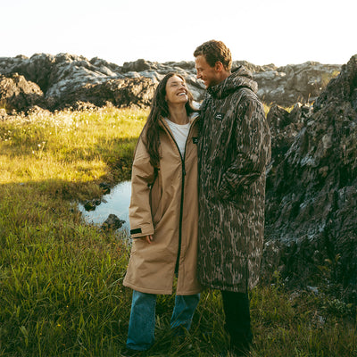 Long waterproof parka coat with hood, outdoor setting.