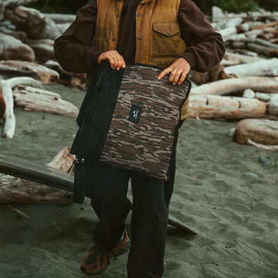 Laptop sleeve in a brown and black camouflage pattern for beach use.