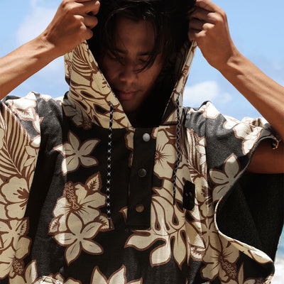 Floral print quick-dry poncho with hood, displayed outdoors in sunlight.