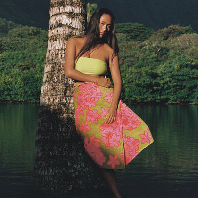 Yellow swimsuit with pink floral beach towel.