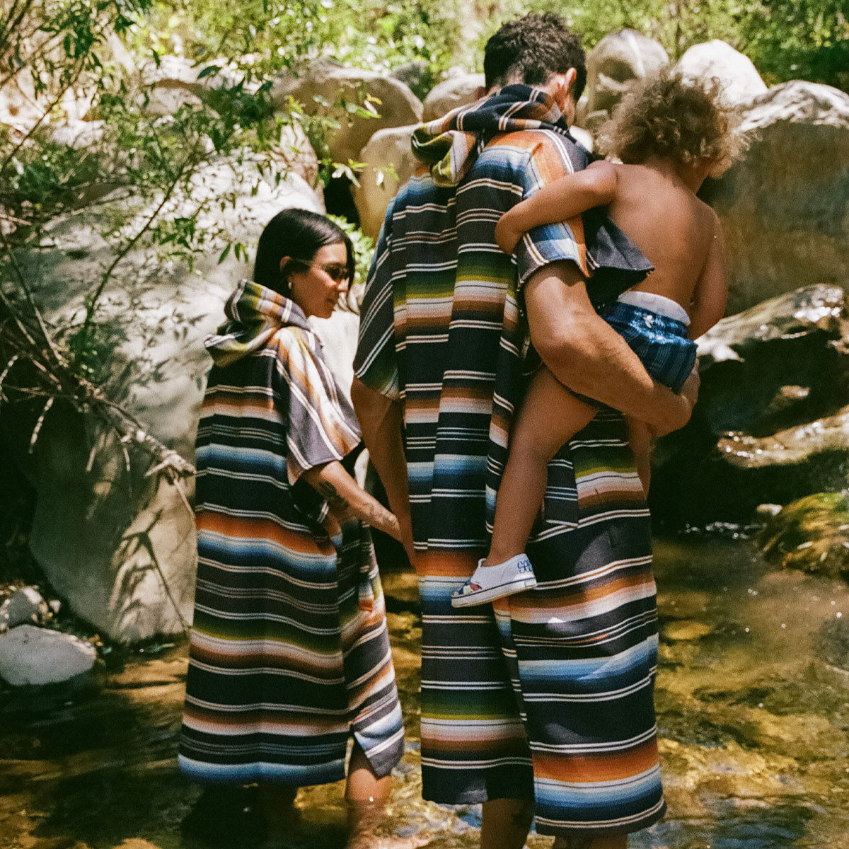 Quick-dry striped ponchos with hood in outdoor beach setting.