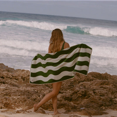 Beach towel in absorbent green and white wavy-striped velour.