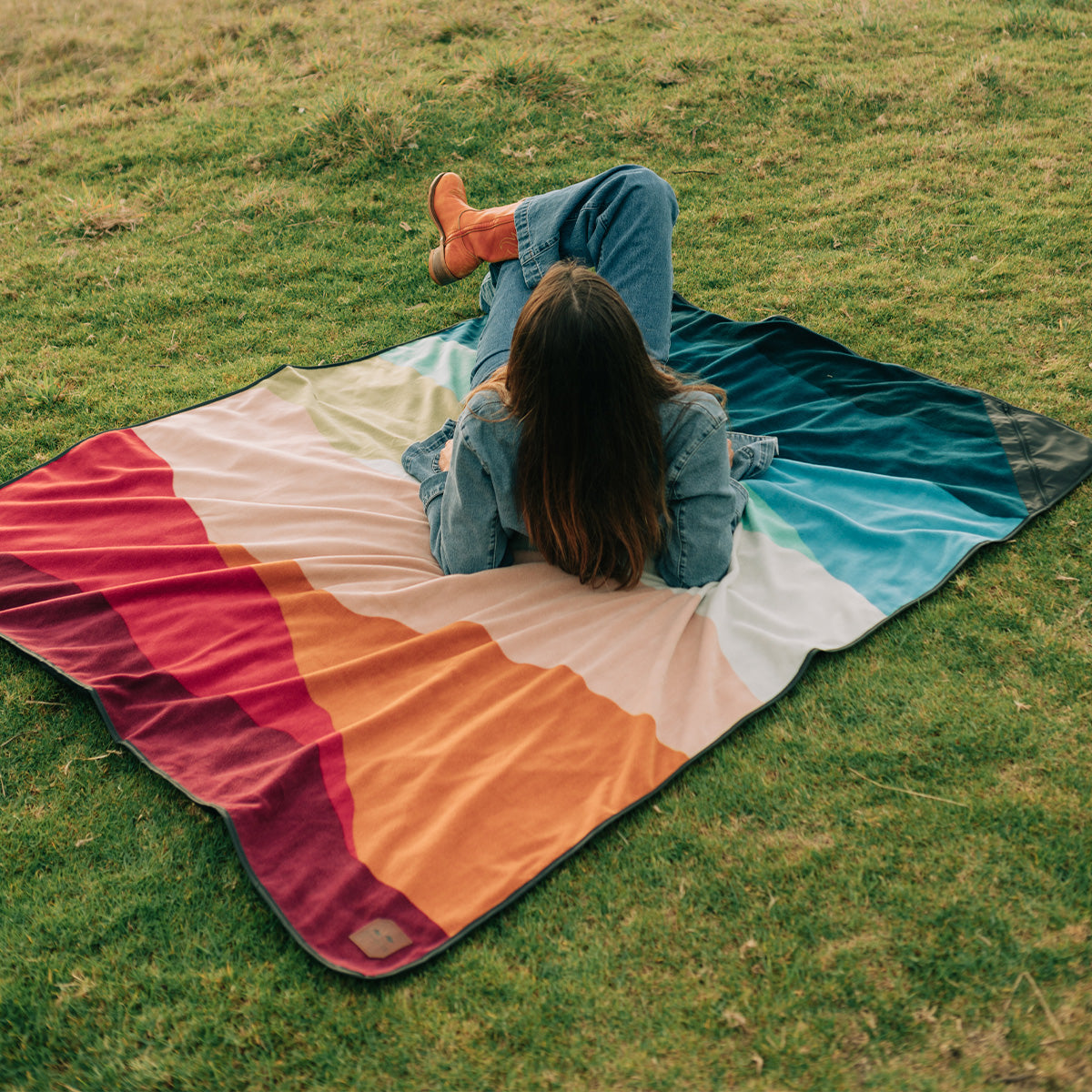 Water-repellent outdoor blanket featuring a geometric mountain pattern on grass.