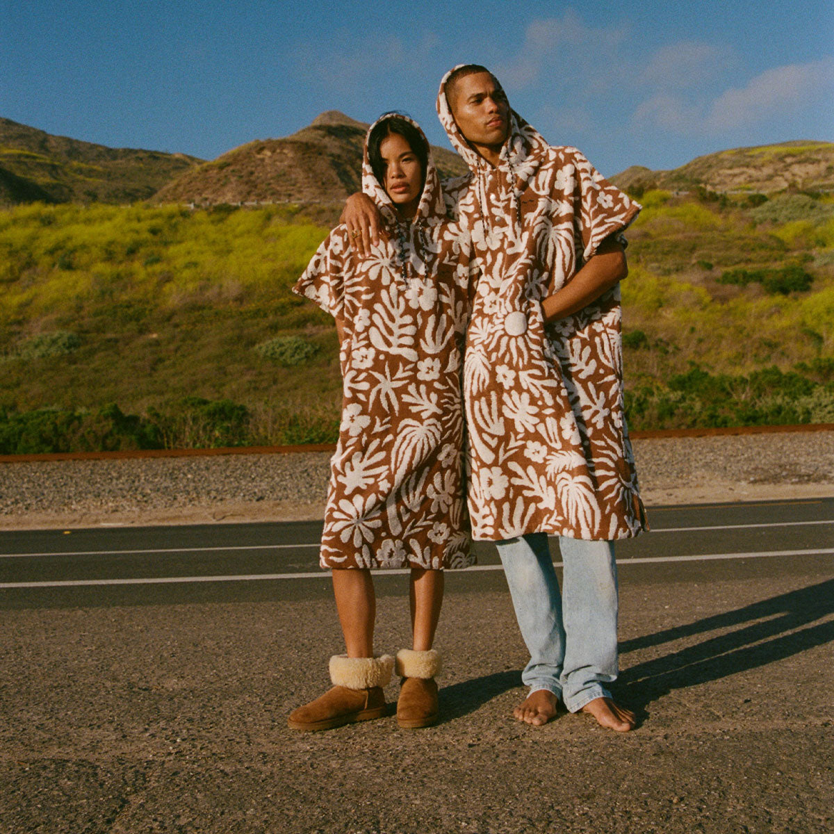 Cotton terry hooded changing ponchos in a brown and white tropical floral print.