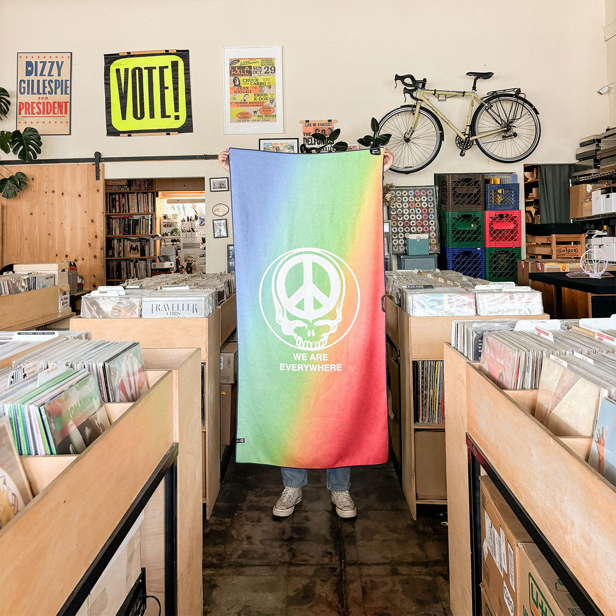 Towel with rainbow gradient, peace sign, and We Are Everywhere slogan on display.