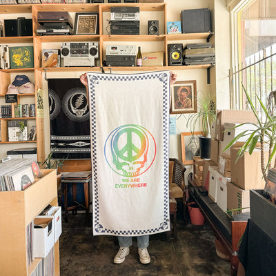 Towel with bold skull and lightning motif on soft fabric in a cozy, plant-filled room.