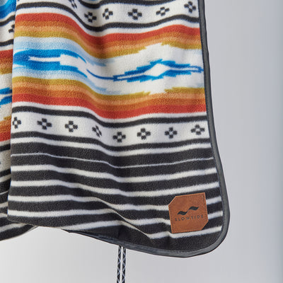Striped fleece outdoor blanket with colorful geometric patterns.